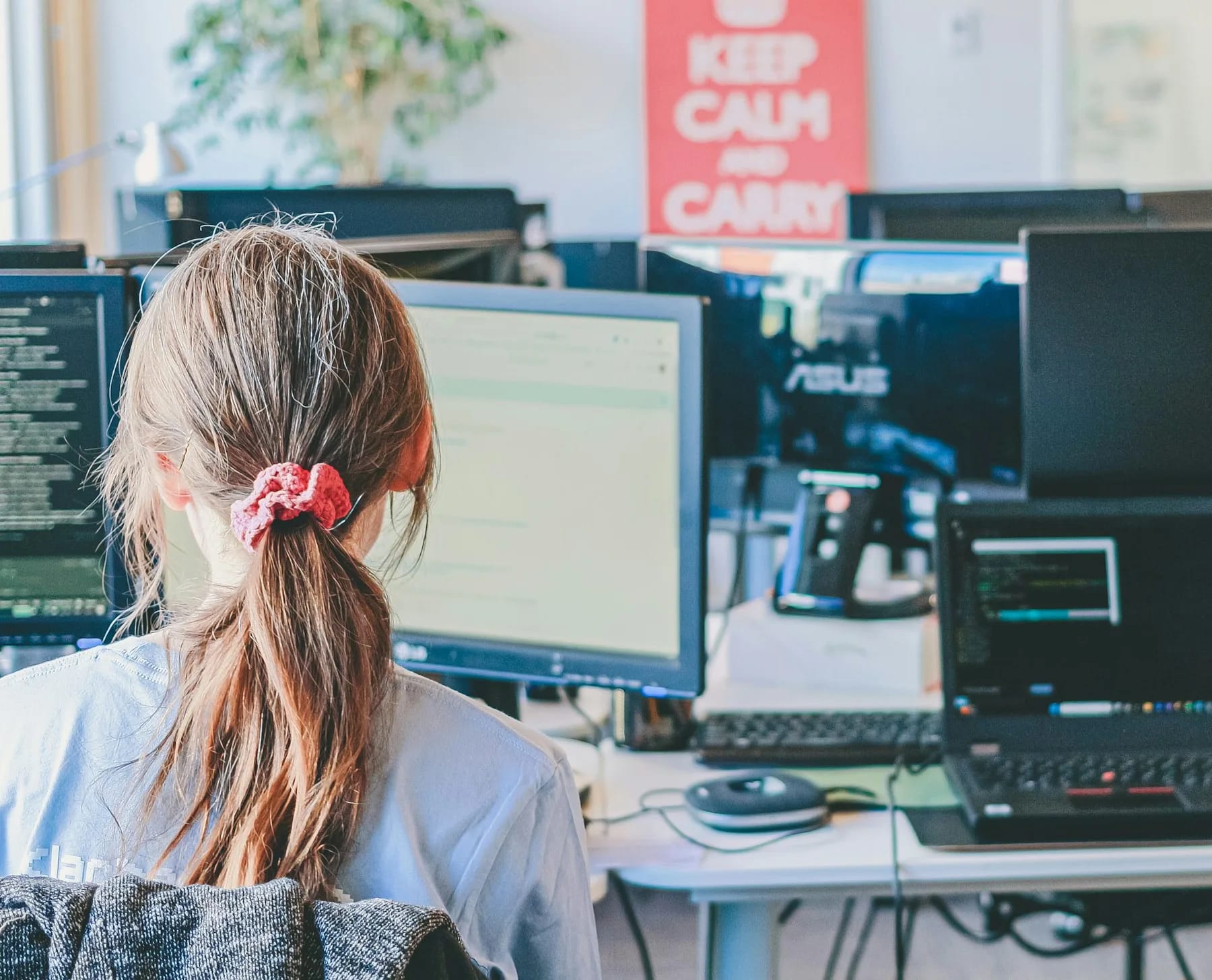 A technology professional working across several computer screens