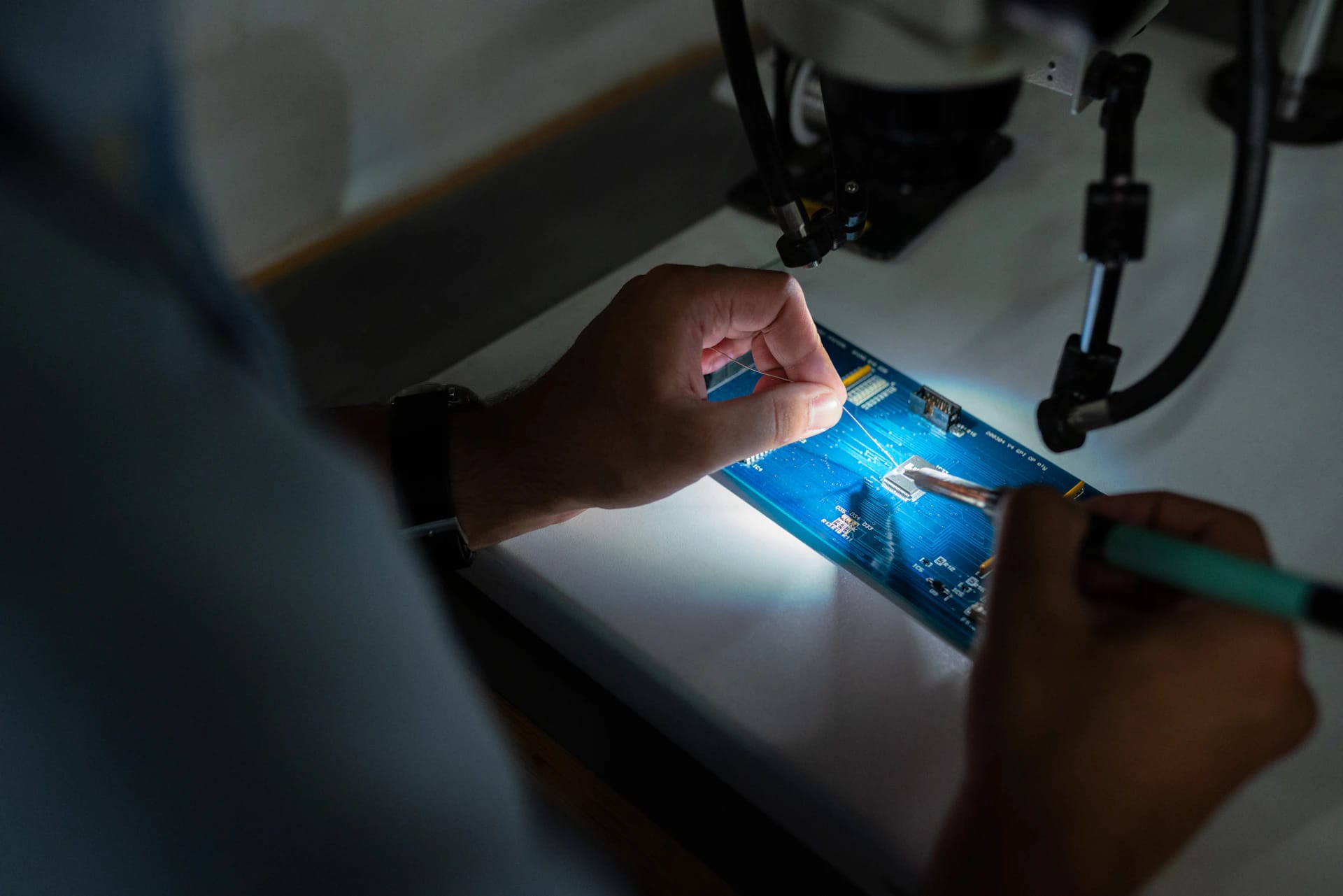 An engineer examining electronic hardware at a workbench