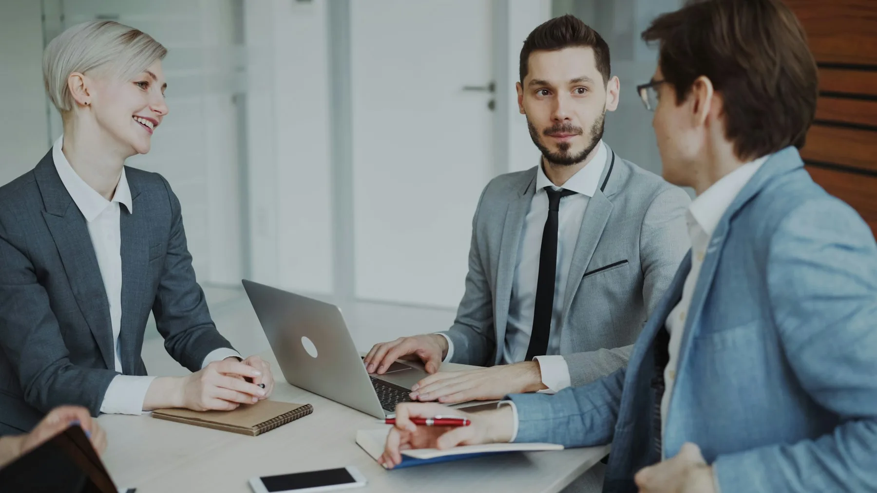 Business professionals discussing a decision around a laptop
