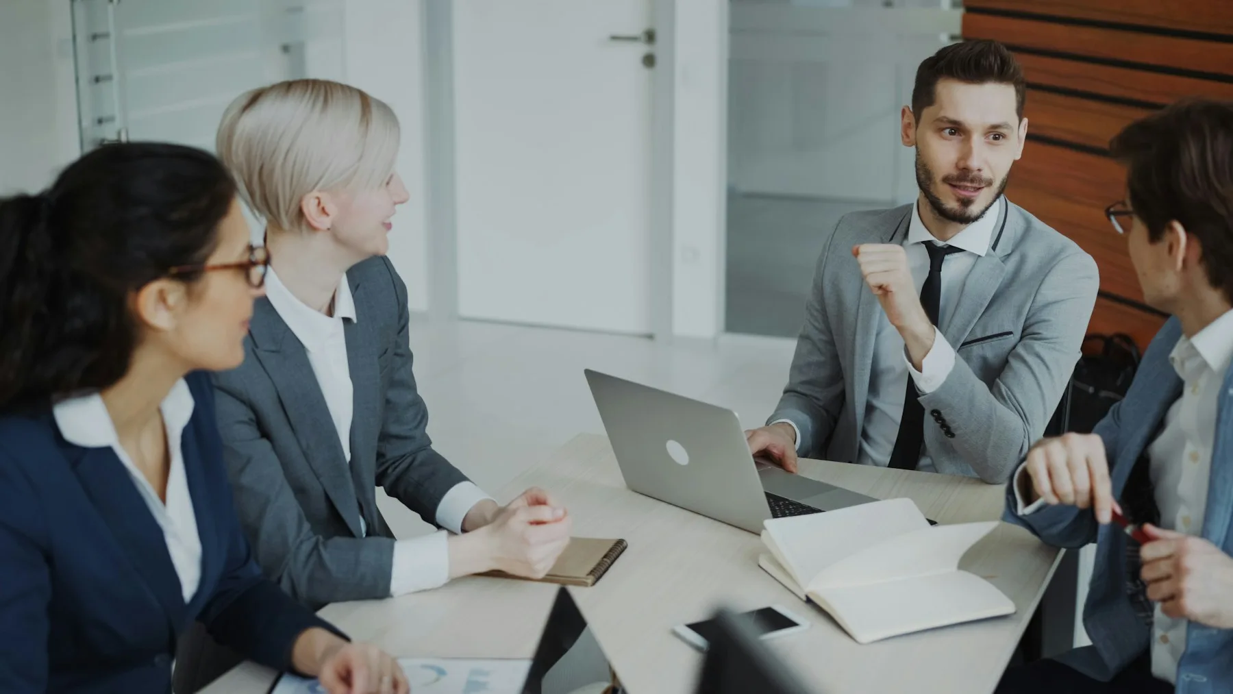 Business professionals reviewing plans around a meeting table